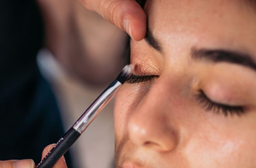 A person carefully applying eye makeup.