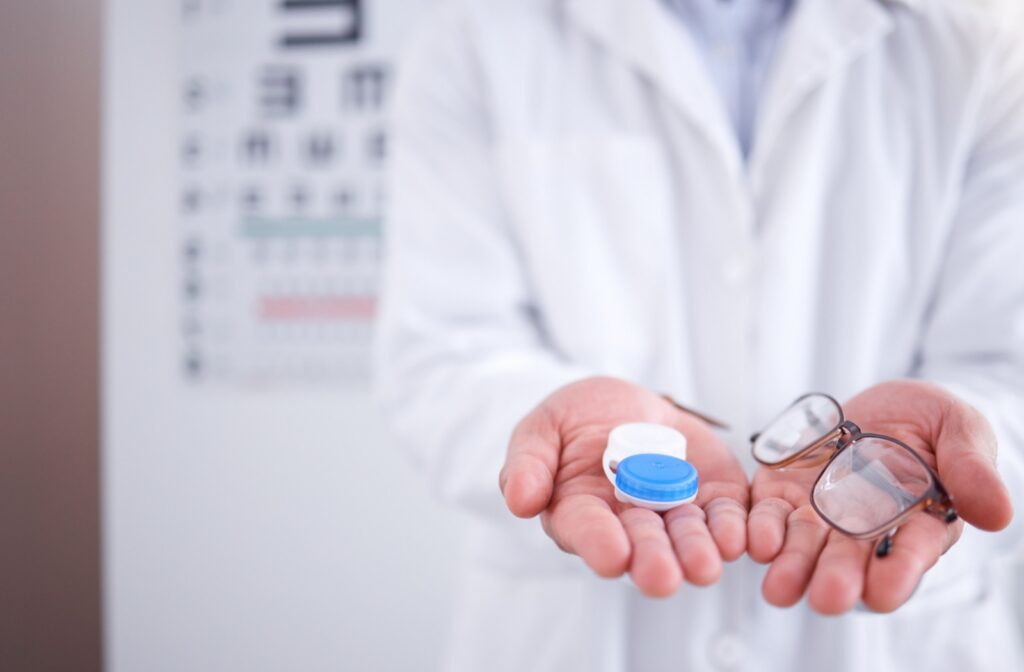 Optometrist holding contact lens case and eyeglasses to show vision correction options.