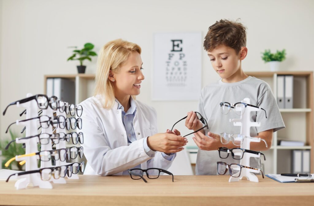 A child looking at glasses with their optometrist after a myopia diagnosis.