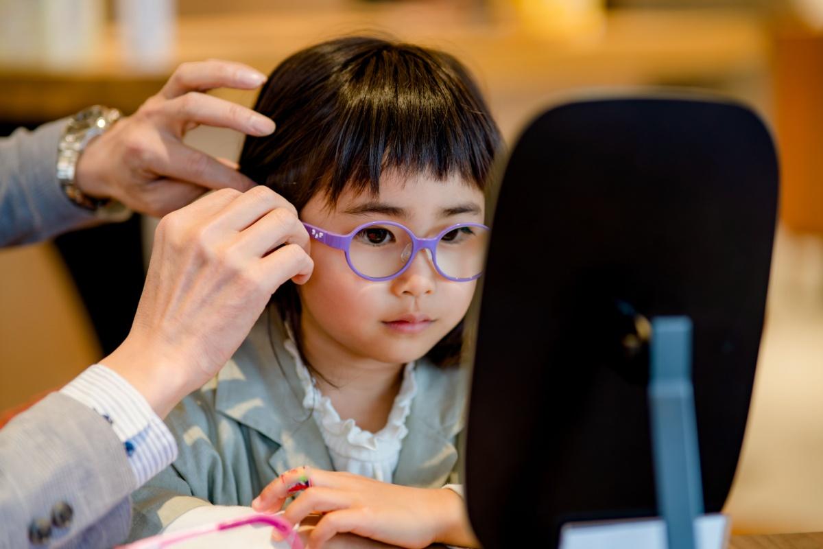 A child having their myopia corrective glasses fitted at their optometrist's office.