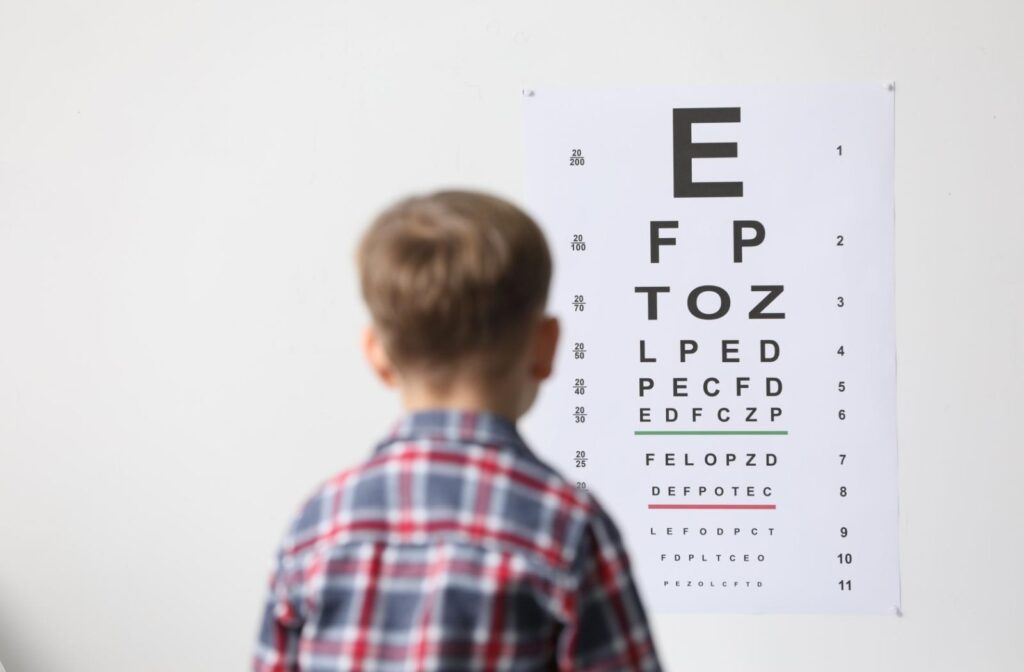 A child looking at a snellen chart during an eye exam.